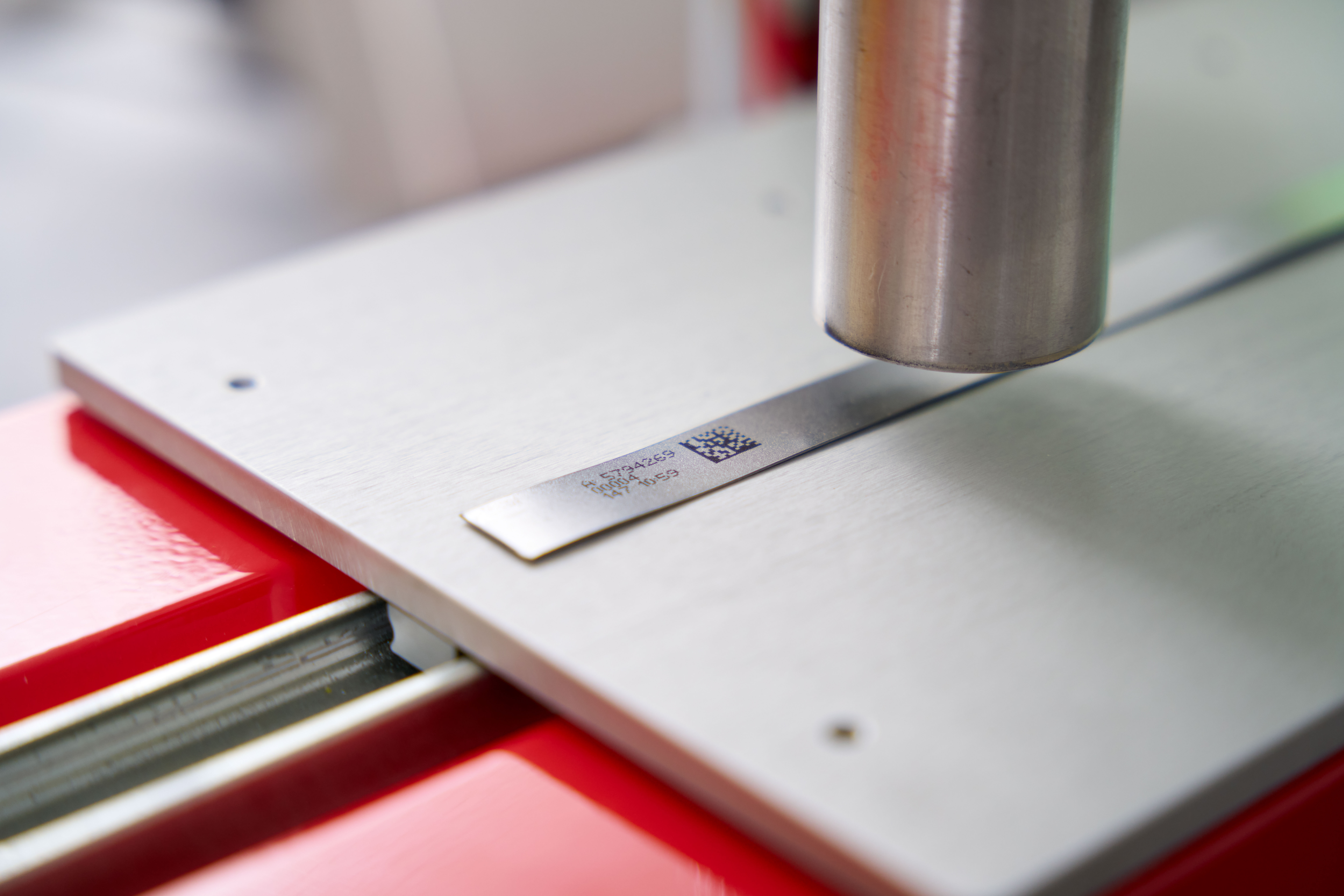 IQJET Industriedrucksystem beim Aufbringen eines QR Codes auf eine Metalloberfläche für präzise Produktkennzeichnung in der Produktion