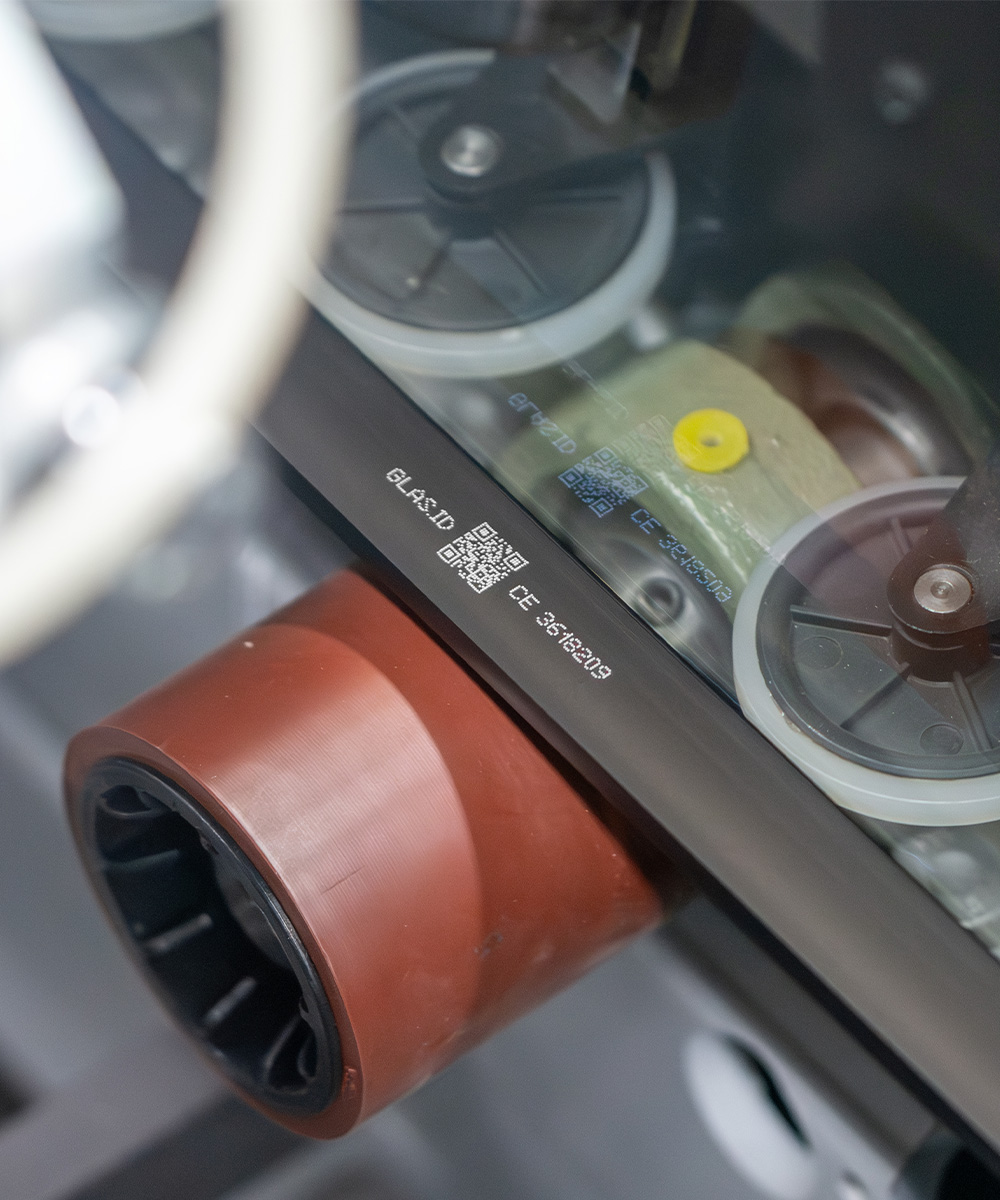 CIJ-gedruckte GLAS.ID mit QR-Code auf einem Glaselement während des Fertigungsprozesses als Digitaler Produktpass.