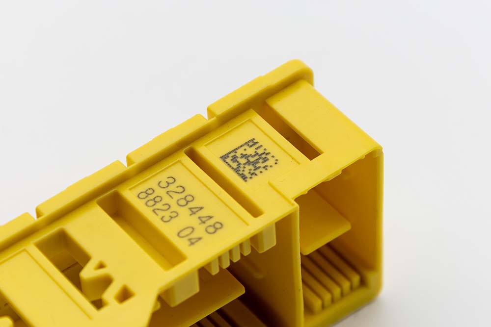Data Matrix Code Produktkennzeichnung mit einem Lasersystem auf einem gelben Kunststoffteil