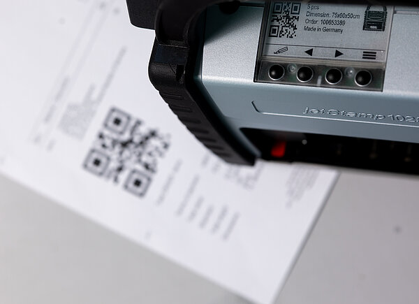 REINER jetStamp 1025 scannt QR-Code auf Dokument mit integriertem Scanner.