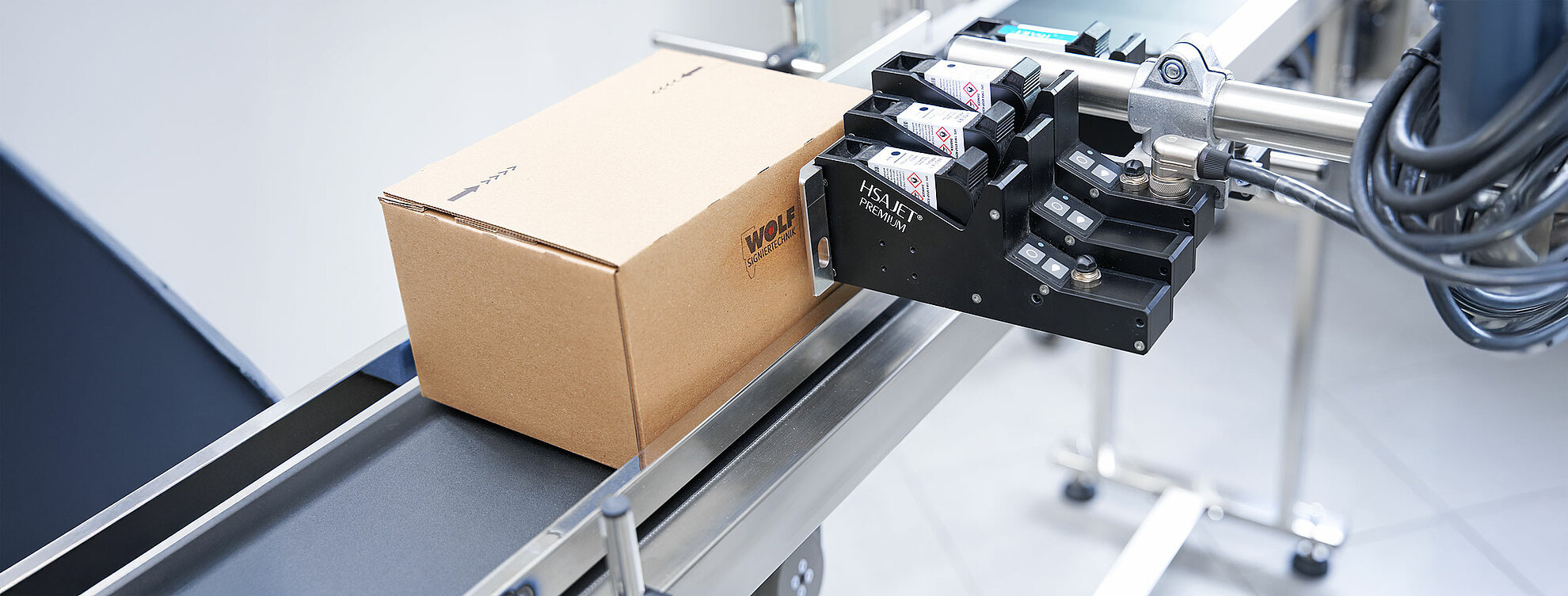 Wolf Signiertechnik Inkjet-Drucksystem beschriftet Kartonverpackung auf Förderband