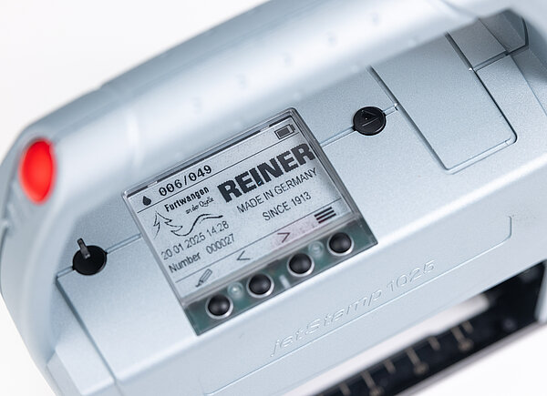 Nahaufnahme des Displays vom REINER jetStamp 1025 mit Druckdaten und Menüanzeige.